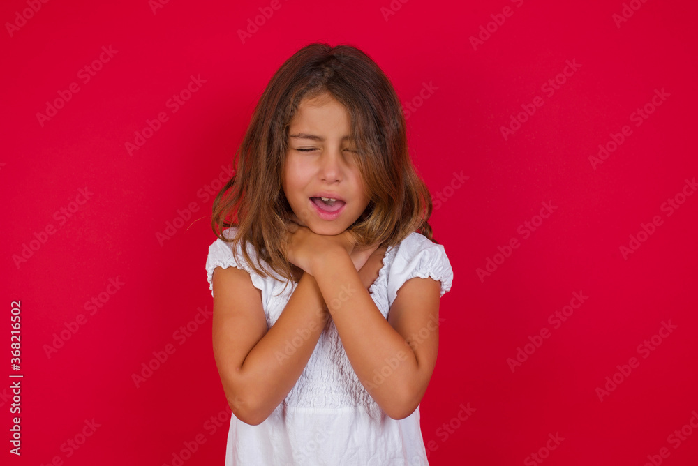 Little caucasian girl with blue eyes wearing white dress standing over isolated red background shouting suffocate because painful strangle. Health problem. Asphyxiate and suicide concept. Little caucasian girl with blue eyes wearing white dress standing over isolated red background shouting suffocate because painful strangle. Health problem. Asphyxiate and suicide concept.