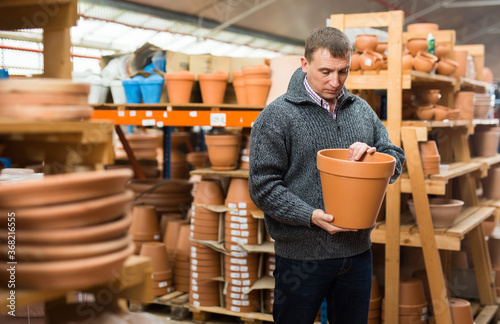 Man chooses pots clay pots in store. High quality photo © JackF