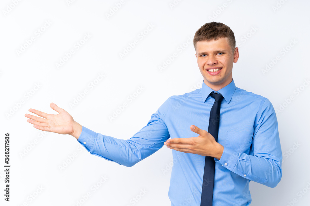 Young handsome businessman extending hands to the side for inviting to come Young handsome businessman extending hands to the side for inviting to come