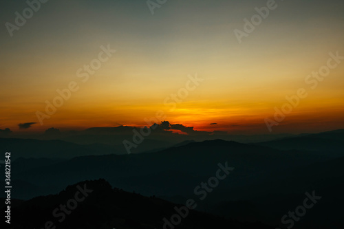 View of silhouatte of mountain range under the sky during the sunset. Beautiful evening nature background.