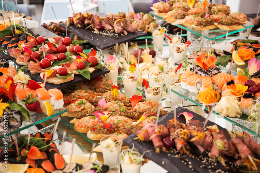 Assortment festive appetizers on the plate, selective focus. Festive buffet. As a photo, for the menu of restaurants, cafes and promotional items. Assortment festive appetizers on the plate, selective focus. Festive buffet. As a photo, for the menu of restaurants, cafes and promotional items.