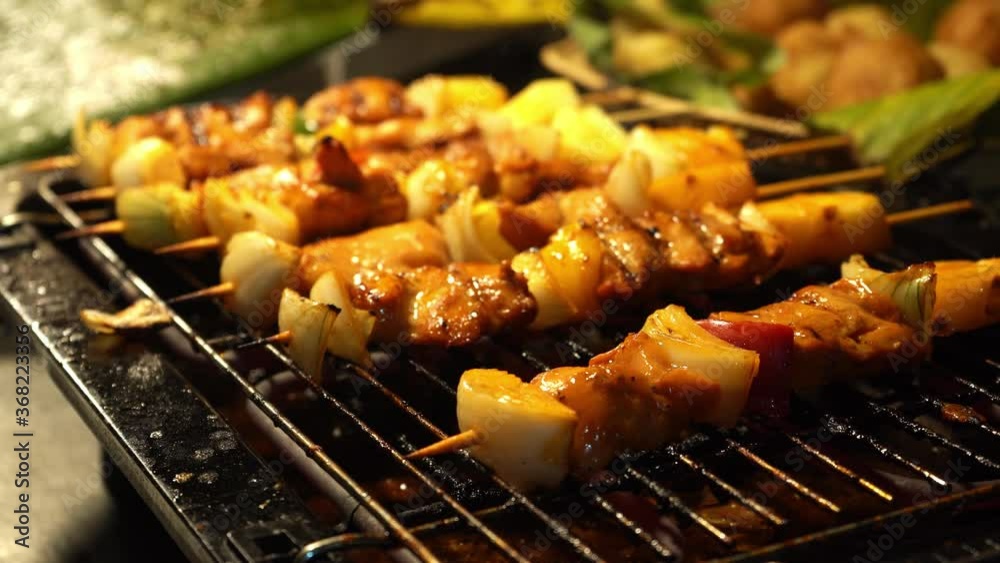 The chef fries satay kebabs on the grill. Flips juicy kebabs on the grill rack The chef fries satay kebabs on the grill. Flips juicy kebabs on the grill rack