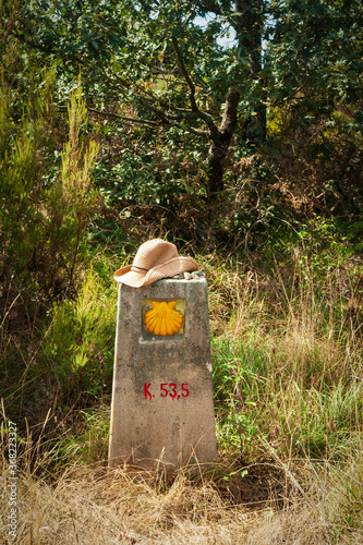 Poste kilometrico de piedra con un sombrero de peregrino encima en el Camino de Santiago