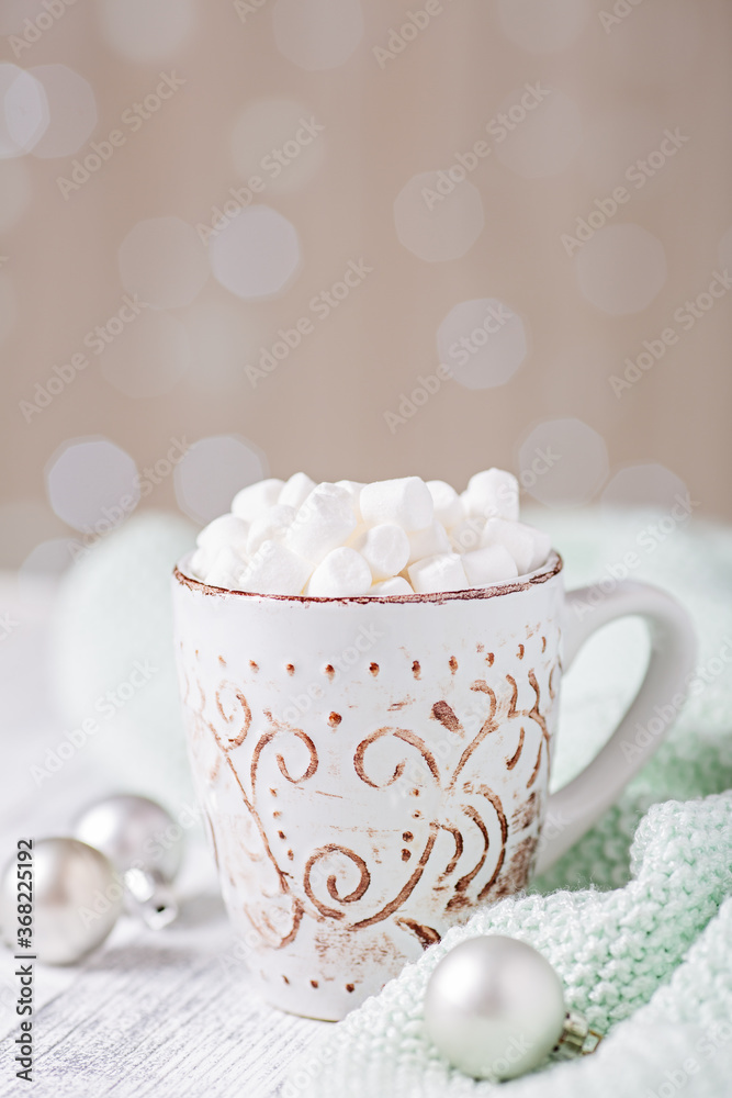 Mug with hot chocolate and marshmallow, sweater. Cozy christmas composition. Hygge concept Soft focus
