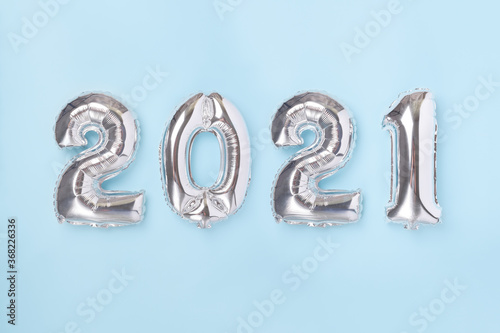 Silver balloons in the form of numbers 2021 on blue background. New year celebration. Happy New Year 2021 concepts