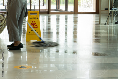 Mopping wet floor in lobby hotel. Background for caution wet floor.