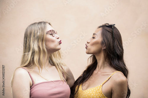 Two girls in front of a pink background