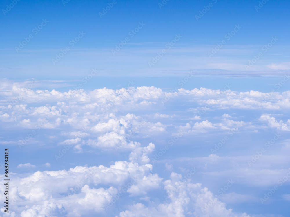 Fototapeta premium Aerial view of cloudscape seen through airplane window