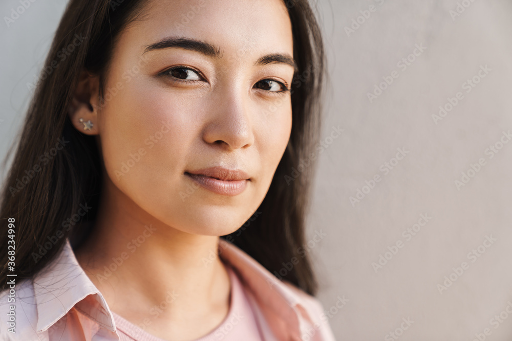 Image of pleased asian beautiful girl looking at camera Image of pleased asian beautiful girl looking at camera