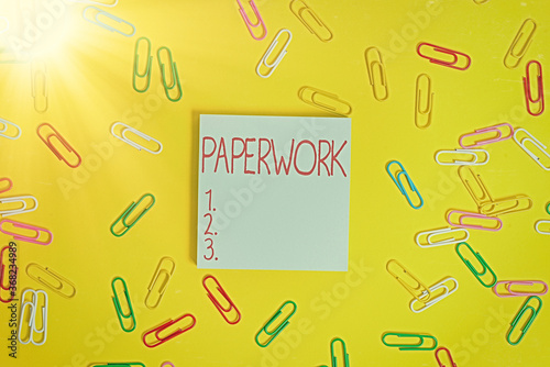 Writing note showing Paperwork. Business concept for routine clerical or recordkeeping work often incidental Flat lay above empty paper with copy space and colored paper clips photo