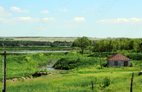 Summer rural landscape with an open-air lake.