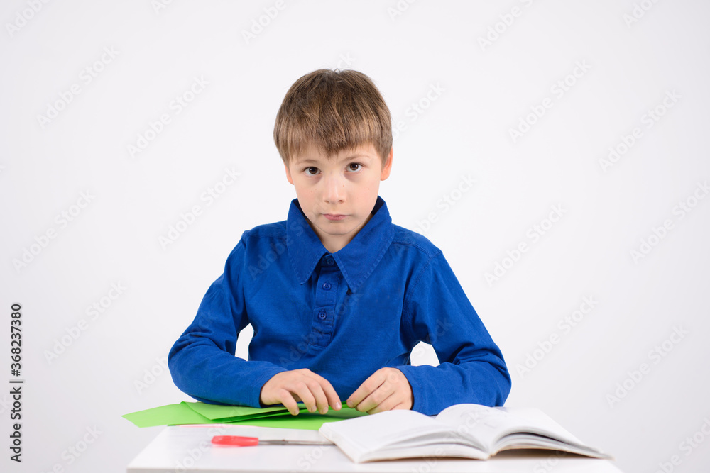 origami: a studious boy learns in the book to make crafts out of origami: a studious boy learns in the book to make crafts out of