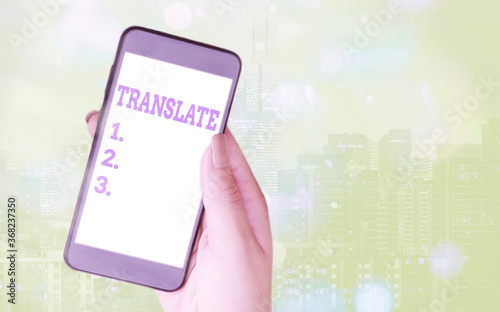 Writing note showing Translate. Business concept for bear, remove, or change from one place, state, form, or appearance Modern gadgets white screen under colorful bokeh background photo