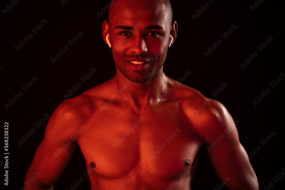 Fototapeta premium Happy smiling fitness man listening music with earphones