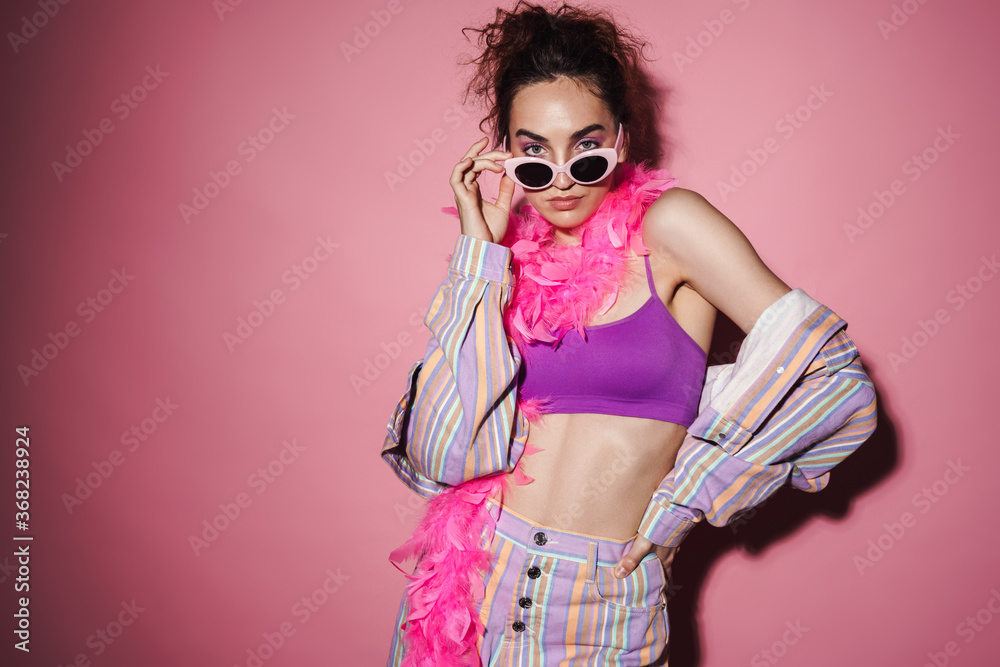 Image of confident woman in sunglasses and boa looking at camera Image of confident woman in sunglasses and boa looking at camera