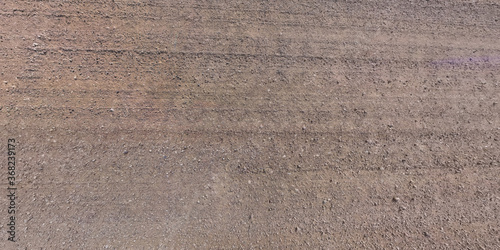 view from above on surface of gravel road with car tire tracks