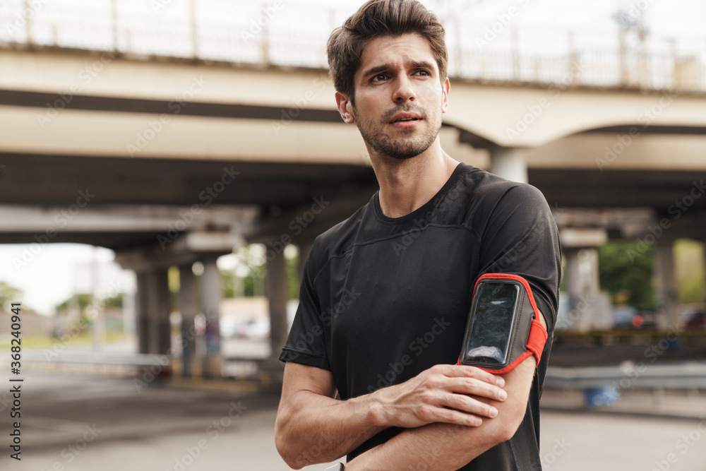Image of athletic sportsman with smartphone working out Image of athletic sportsman with smartphone working out