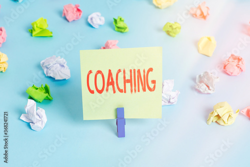 Word writing text Coaching. Business photo showcasing to instruct, direct, or prompt as a coach to subordinates Colored crumpled papers empty reminder blue floor background clothespin photo