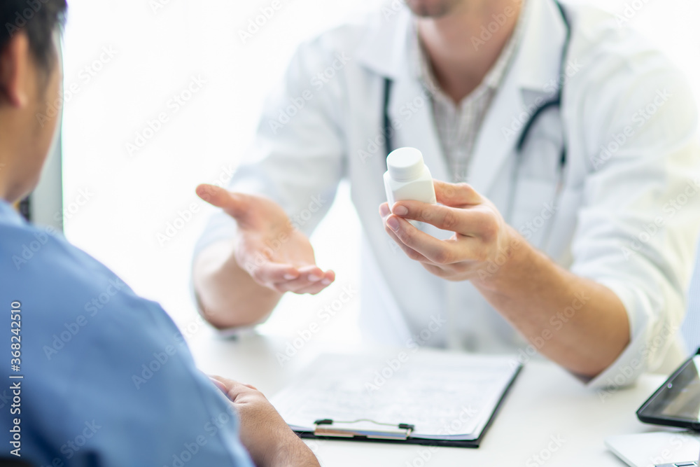 A doctor explain illness symptoms and medicine using instruction to a patient in diagnosis room in hospital. A doctor explain illness symptoms and medicine using instruction to a patient in diagnosis room in hospital.