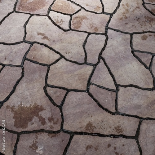 Modern flagstone mosaic tiles slabs with random chaotic texture for stone wall ,patio floor or terrace construction. Abstract background of brown sandstone slabs with cracked lines on garden walkway.