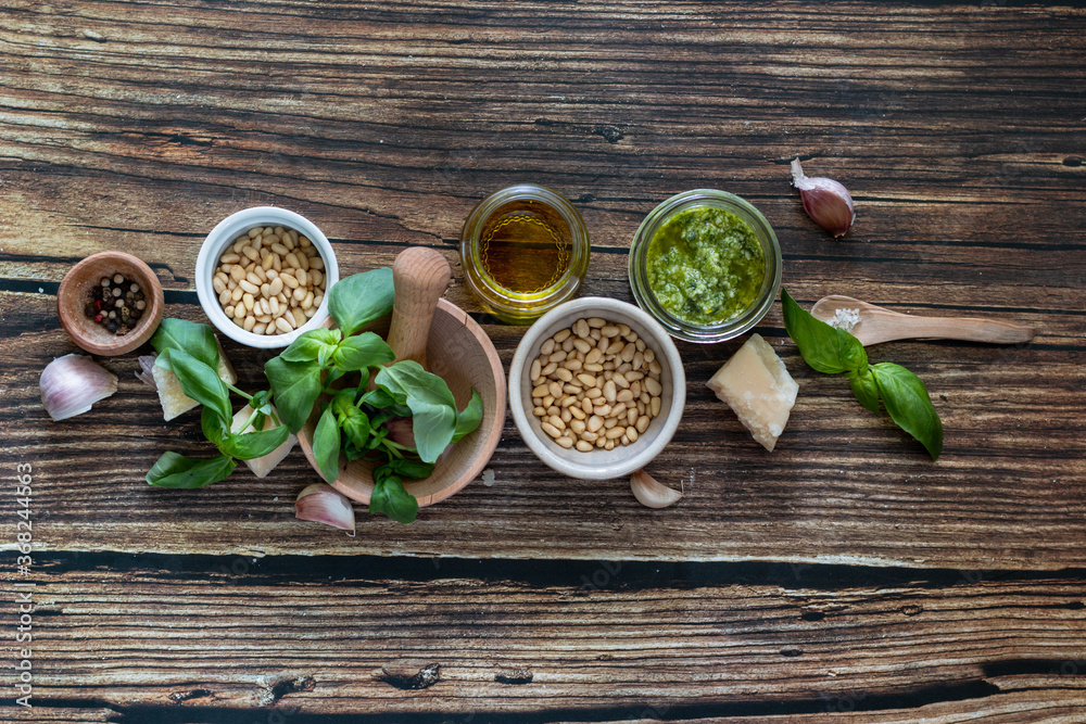 ingredients to cook homemade italian sauce pesto basil, garlic, parmigiano, olive oil and pine nuts horizontale