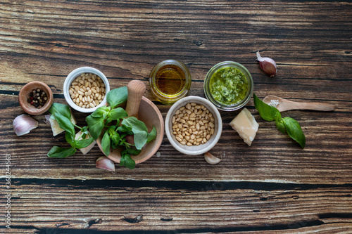 ingredients to cook homemade italian sauce pesto basil, garlic, parmigiano, olive oil and pine nuts horizontale