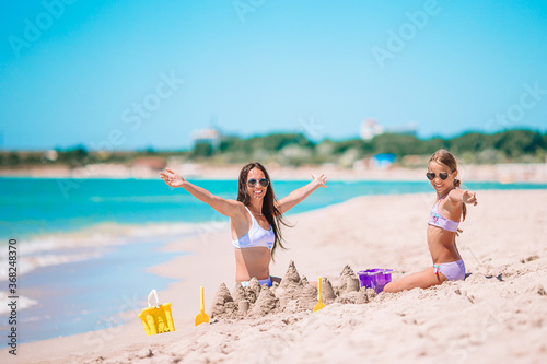 Beautiful mother and daughter on the beach enjoying summer vacation
