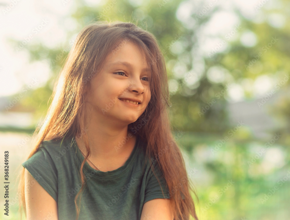Happy smiling calm kid girl on the grass on nature summer background. Closeup positive Happy smiling calm kid girl on the grass on nature summer background. Closeup positive