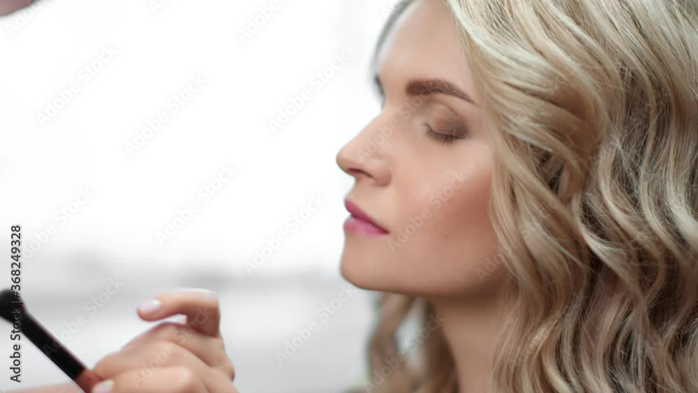 Closeup hand of makeup artist applying eyeshadow on closed eyes. Shot on RED Raven 4k Cinema Camera Closeup hand of makeup artist applying eyeshadow on closed eyes. Shot on RED Raven 4k Cinema Camera
