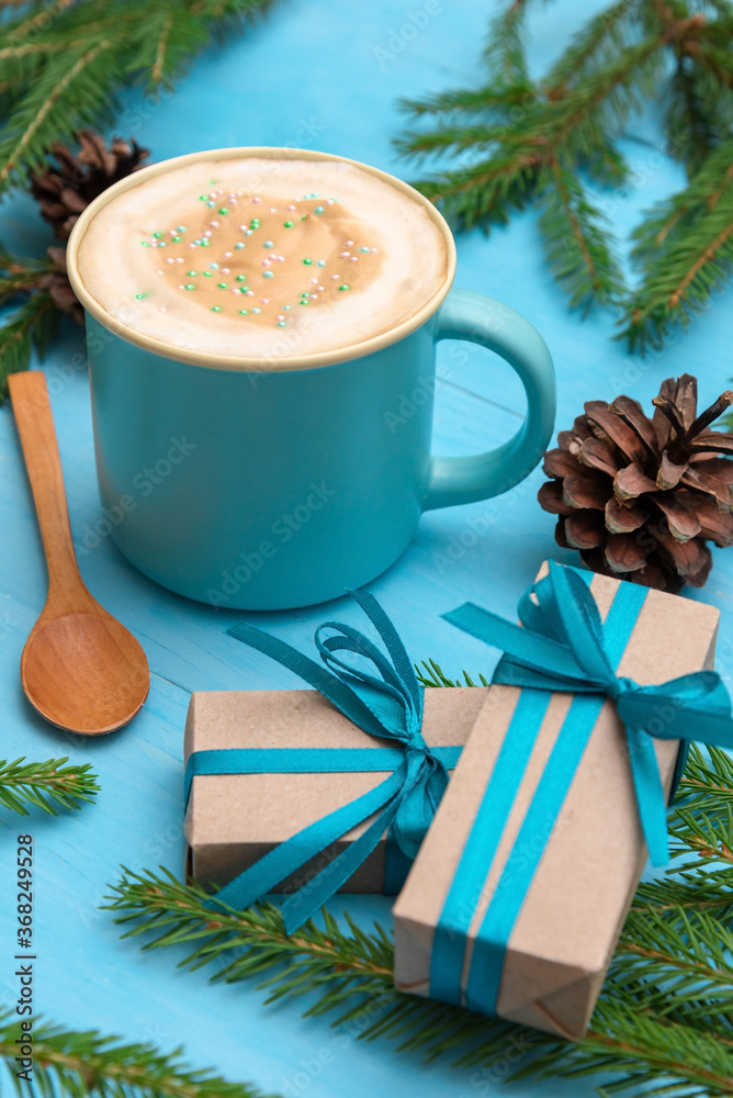 Delicious coffee with foam on new year's day with gifts and fir branches.