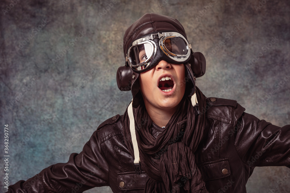 boy playing to be older in aviator suit on smooth background boy playing to be older in aviator suit on smooth background