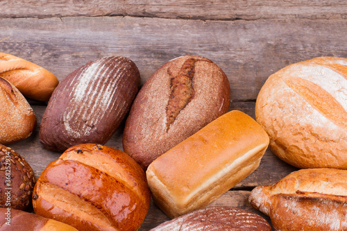Various types of bread on wooden background. Healthy organic bread.