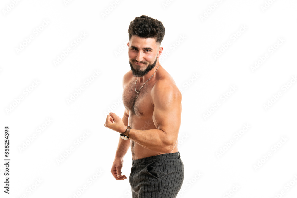 Sport, gym and strength concept. Sexy good-looking muscular young man in perfect shape, standing with naked torso, raising hand proudly showing strong big muscles Sport, gym and strength concept. Sexy good-looking muscular young man in perfect shape, standing with naked torso, raising hand proudly showing strong big muscles