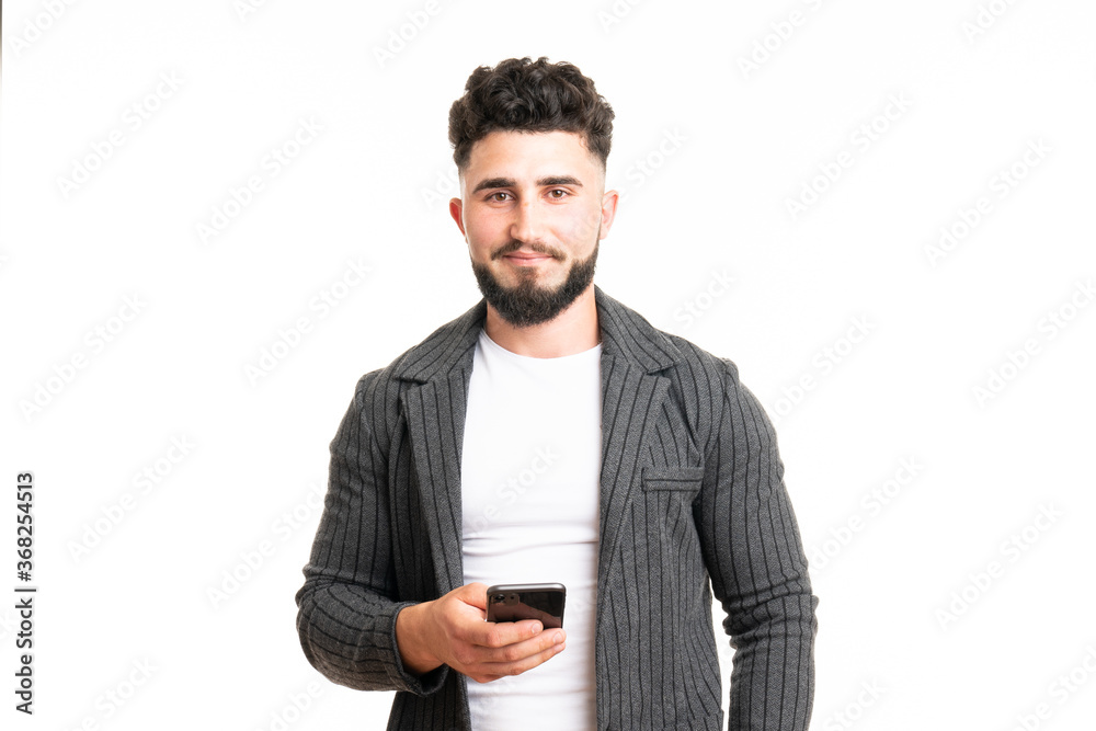 Positive European American male with smile, holds modern cell phone, types text message and feedback, surfes social networks, rejoices high speed interent connection Positive European American male with smile, holds modern cell phone, types text message and feedback, surfes social networks, rejoices high speed interent connection