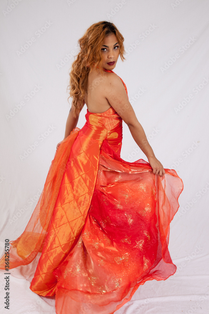Pretty Hispanic woman playing with her flowing orange dress Pretty Hispanic woman playing with her flowing orange dress