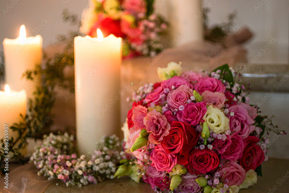 Obraz premium brides flower bouquet next to a candle in a church