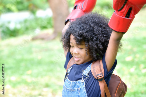 African American little boy play Boxing gloves at nature park.
