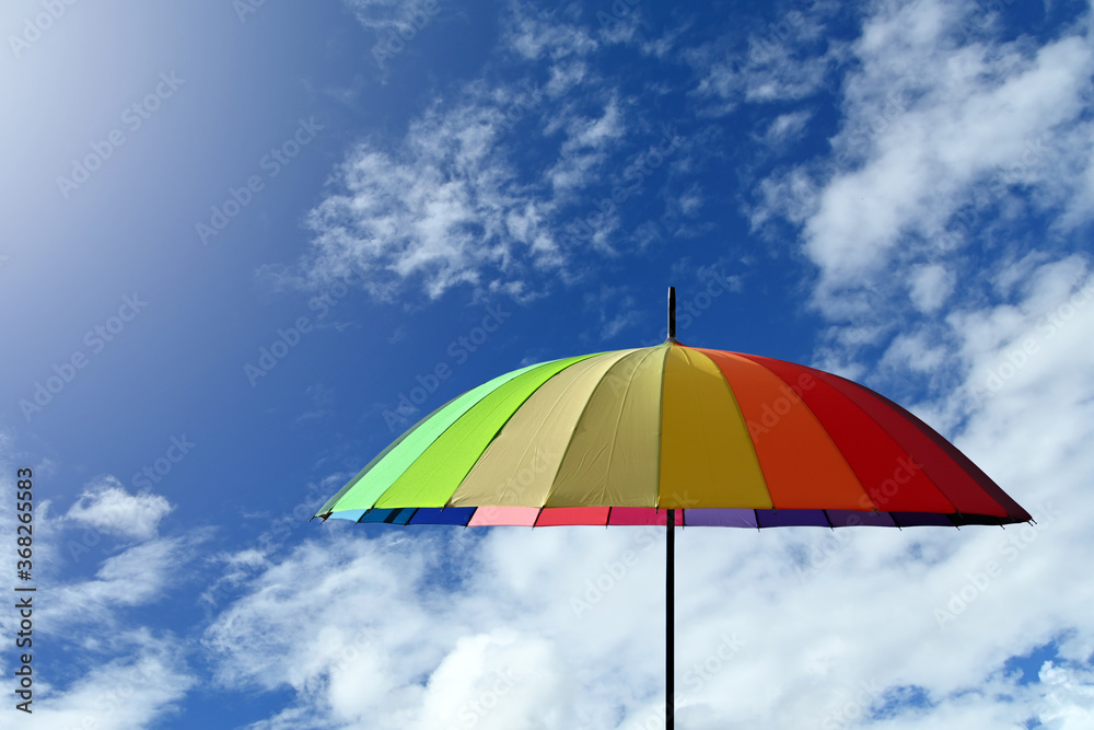 Colorful umbrella multicolored on a blue sky background