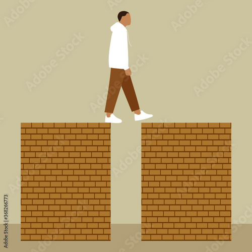 
A man steps from one brick wall to another