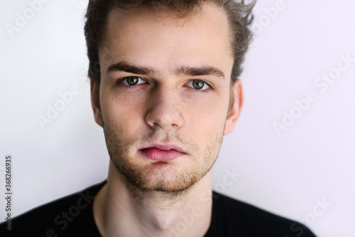 Portrait, face of a teenager, a young guy close-up, isolated on a light background