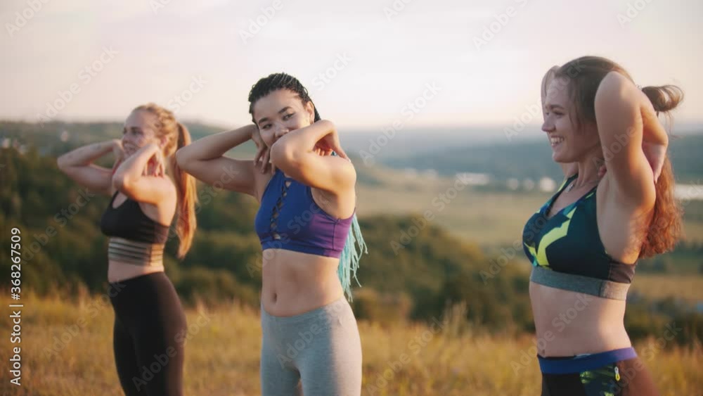 Three young women in sports clothes doing aerobic exercises Three young women in sports clothes doing aerobic exercises