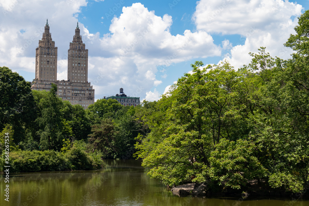 Central Park Lake with Green Trees during Summer with a view of the Upper West Side in New York City Central Park Lake with Green Trees during Summer with a view of the Upper West Side in New York City