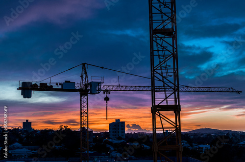 Construction site cranes against a fading sunset in Brisbane, Queensland, Australia 