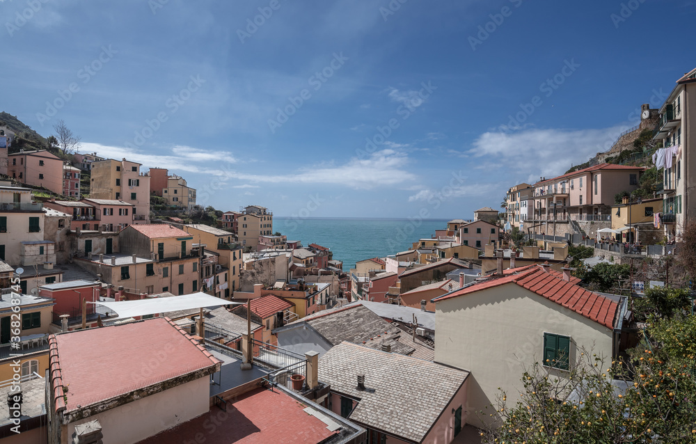 View of Riomaggiore village, first & most southern of Cinque Terre coastal villages, located in a small & narrow valley, as seen from east towards the Mediterranean sea, La Spezia, Liguria region, Ita