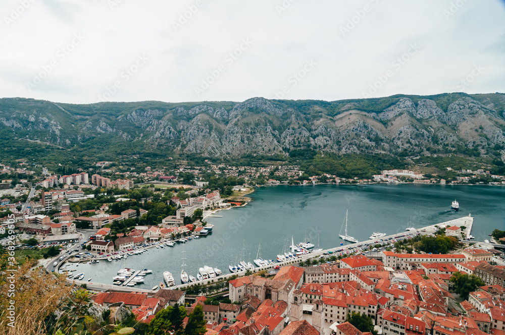 Landscape in Montenegro.  
Bird's eye view of Boko-Kotor Bay. In the photo - old masonry buildings, cherished roofs, sharp roof spiers against the backdrop of green mountains and the blue Adriatic bay