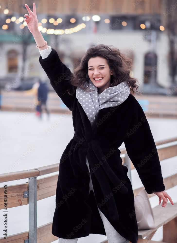 Brunette model makes fun near the city ice rink in the winter