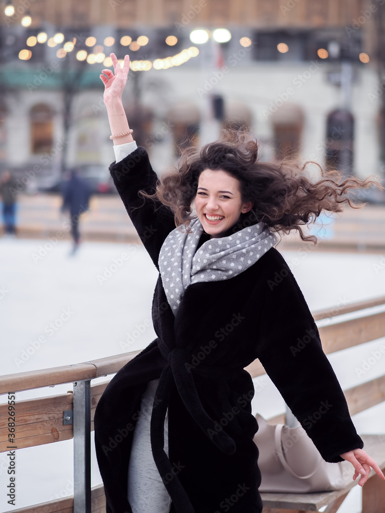 Brunette model makes fun near the city ice rink in the winter