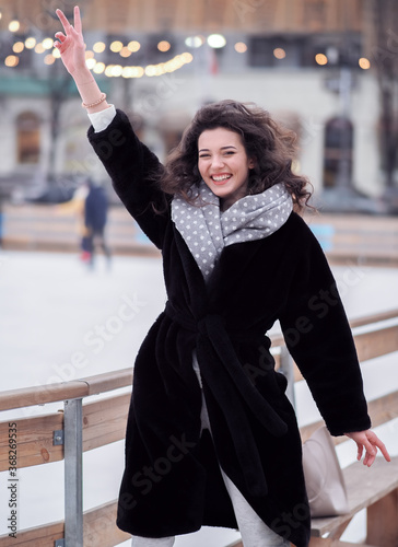 Obraz na płótnie Brunette model makes fun near the city ice rink in the winter w salonie