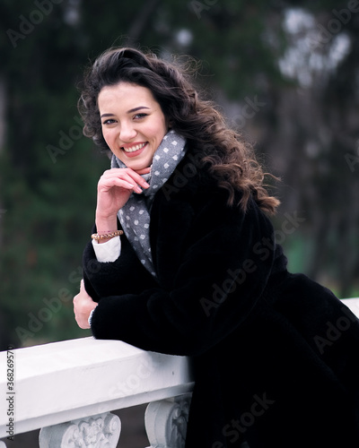 Obraz na płótnie Brunette model with curly hait posing at the city streets w salonie