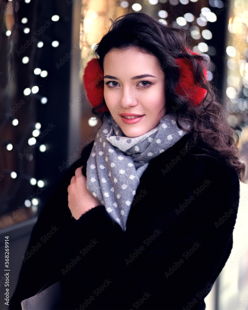 Brunette model posing near lights at the evening at the city